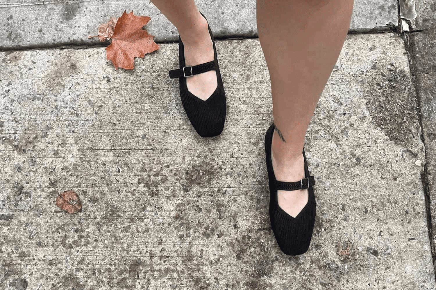 Стильна жінка в зручних кросівках та елегантному пальто