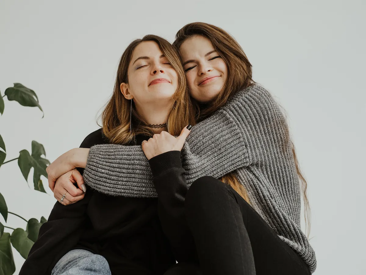 Подруги обнимаются и смеются